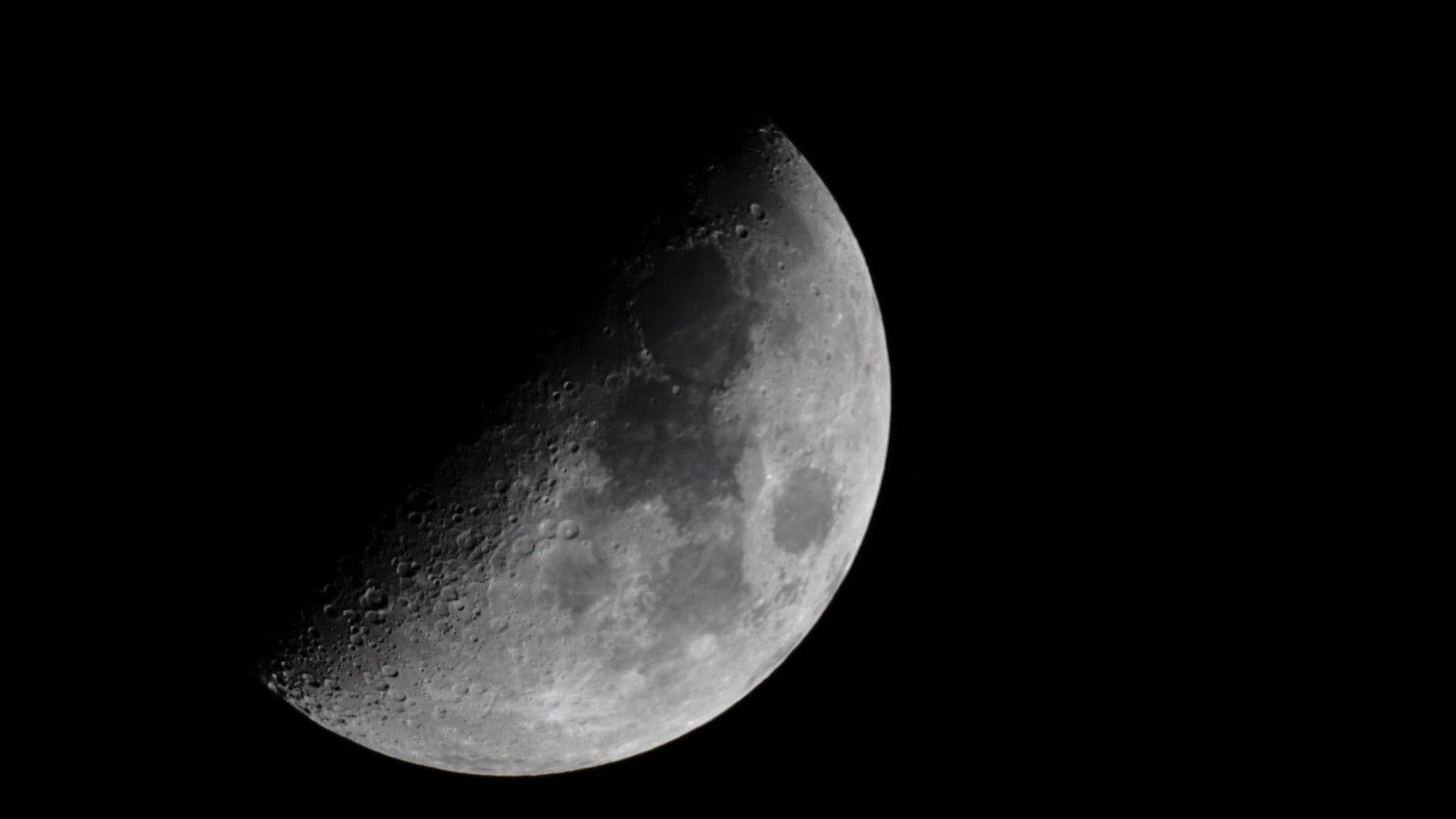Partial view of the moon through a telescope against a black background